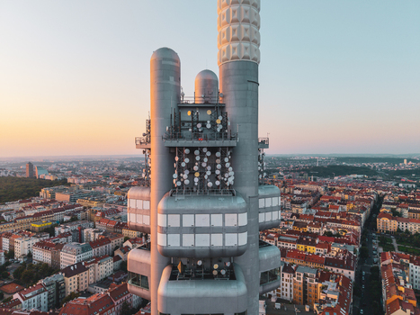 Aerial view of Zizkov Television Tower with futuristic architecture and antennas rising above historic rooftops during golden hour Hlavni mesto Praha Hlavni mesto Praha Czechia.