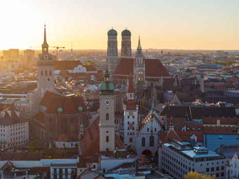 Aerial view of the historic city center featuring the Frauenkirche domes and New Town Hall tower during golden hour Munich Bavaria Germany. Aerial view of the historic city center featuring the Frauenkirche domes and New Town Hall tower during golden hour Munich Bavaria Germany.