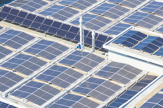 Aerial view of a large array of solar panels installed on a flat industrial rooftop in Arezzo Tuscany Italy. Aerial view of a large array of solar panels installed on a flat industrial rooftop in Arezzo Tuscany Italy.