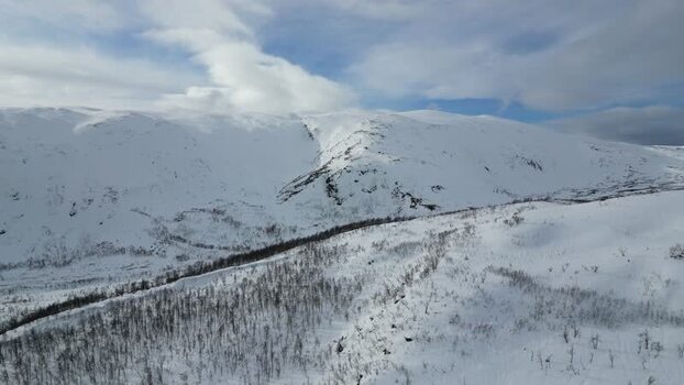 Aerial view of snowy mountains on Kvaloya island Norway.