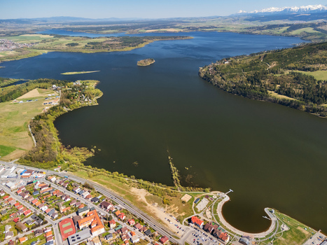 Aerial view of Oravska priehrada reservoir with its small island surrounding green hills and the town of Namestovo Zilinsky kraj Slovakia. Aerial view of Oravska priehrada reservoir with its small island surrounding green hills and the town of Namestovo Zilinsky kraj Slovakia.