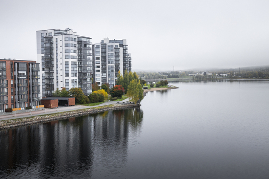 View of modern apartment buildings along the shore of a lake with autumn foliage and an overcast sky in Jyvaskyla Central Finland Finland.