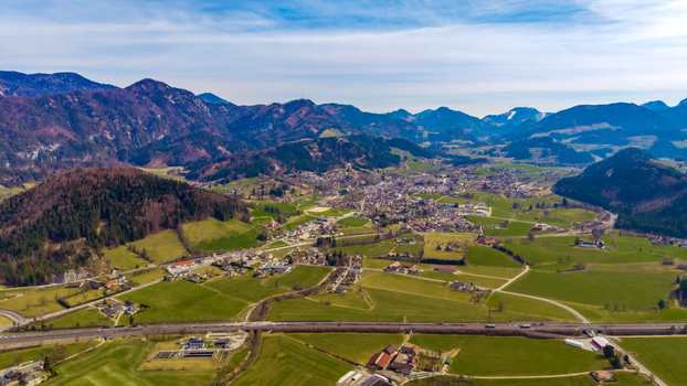 Aerial view of the vibrant green valley floor meeting the quaint town nestled against the backdrop of majestic mountains Windischgarsten Upper Austria Austria. Aerial view of the vibrant green valley floor meeting the quaint town nestled against the backdrop of majestic mountains Windischgarsten Upper Austria Austria.