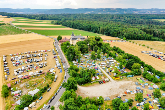 Aerial view of Schloss Jagersburg surrounded by a large campsite with tents and caravans amidst green fields and forests in Eggolsheim Bayern Germany. Aerial view of Schloss Jagersburg surrounded by a large campsite with tents and caravans amidst green fields and forests in Eggolsheim Bayern Germany.