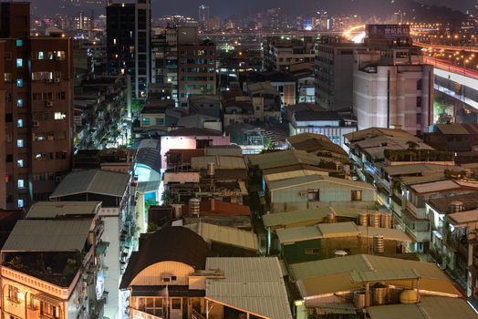 View of the dense urban landscape of Sanchong District at night featuring residential rooftops illuminated buildings and light trails in Sanchong District New Taipei City Taiwan. View of the dense urban landscape of Sanchong District at night featuring residential rooftops illuminated buildings and light trails in Sanchong District New Taipei City Taiwan.