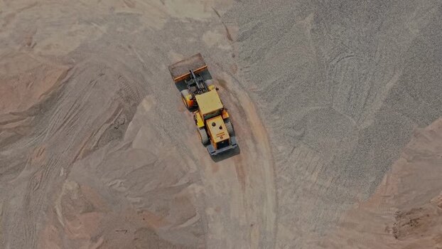 Aerial view of a yellow bulldozer in a gravel pit Indonesia.