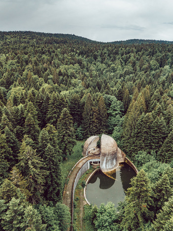Aerial view of the Korcanica Memorial Zone monument surrounded by dense pine forest on Grmec Mountain in Sanski Most Federation of Bosnia Bosnia and Herzegovina. Aerial view of the Korcanica Memorial Zone monument surrounded by dense pine forest on Grmec Mountain in Sanski Most Federation of Bosnia Bosnia and Herzegovina.