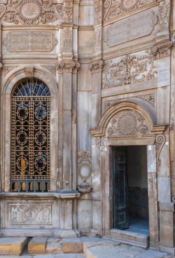 View of Sabil Kuttab of Muhammad Ali Pasha with its intricate stone carvings ornate metal window grilles and an open doorway in Cairo Egypt. View of Sabil Kuttab of Muhammad Ali Pasha with its intricate stone carvings ornate metal window grilles and an open doorway in Cairo Egypt.