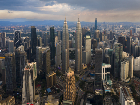 Kuala Lumpur Malaysia 11 March 2026 Aerial view of the Petronas Twin Towers and the surrounding urban skyline under a dramatic sky.