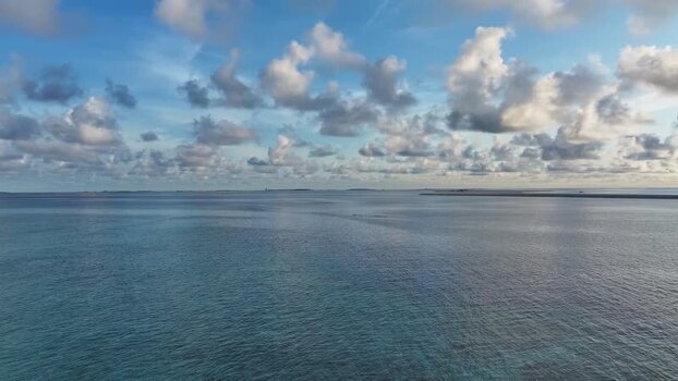 Aerial view of the turquoise ocean waters under a cloudy blue sky Maldives. Aerial view of the turquoise ocean waters under a cloudy blue sky Maldives.