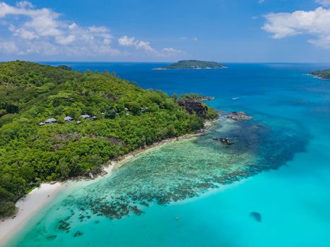 Aerial view of lush greenery meets the turquoise sea revealing a hidden beach paradise along the coast Victoria Mahe Island Seychelles. Aerial view of lush greenery meets the turquoise sea revealing a hidden beach paradise along the coast Victoria Mahe Island Seychelles.