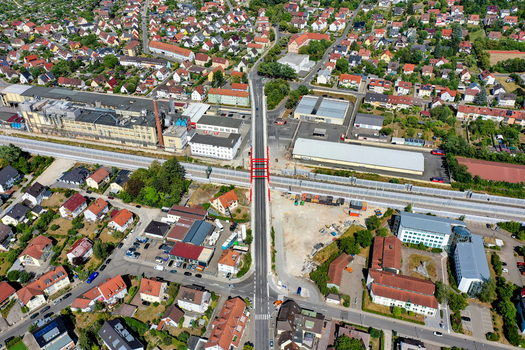 Aerial view of Piastenbrucke bridge crossing over railway tracks surrounded by residential houses and industrial buildings in Forchheim Bayern Germany.