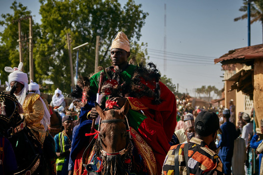 Zaria city Nigeria 22 March 2026 View of a regal figure in vibrant green and crimson atop a richly adorned horse amidst a sun drenched procession. Zaria city Nigeria 22 March 2026 View of a regal figure in vibrant green and crimson atop a richly adorned horse amidst a sun drenched procession.