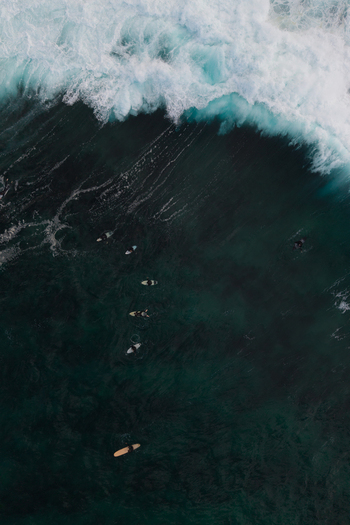 Aerial view of surfers waiting for waves in the deep blue ocean at Dee Why New South Wales Australia.