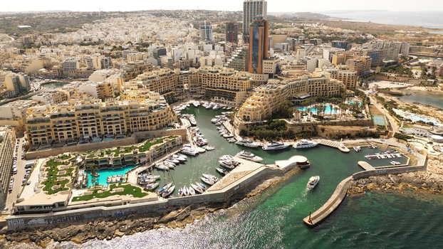 Aerial view of Portomaso Marina with luxury yachts and boats docked in the harbor surrounded by modern residential buildings and hotels in St. Julian s Malta. Aerial view of Portomaso Marina with luxury yachts and boats docked in the harbor surrounded by modern residential buildings and hotels in St. Julian s Malta.