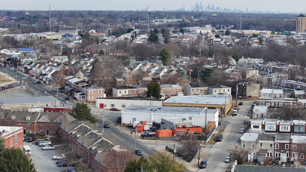Aerial view of the residential and industrial landscape with rows of houses streets and a distant city skyline in the background in Chester Pennsylvania United States. Aerial view of the residential and industrial landscape with rows of houses streets and a distant city skyline in the background in Chester Pennsylvania United States.