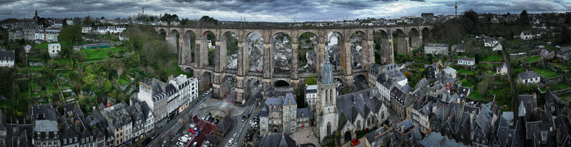 Aerial view of the Eglise Saint Melaine de Morlaix and the massive stone viaduct spanning the valley over historic rooftops Morlaix Bretagne France. Aerial view of the Eglise Saint Melaine de Morlaix and the massive stone viaduct spanning the valley over historic rooftops Morlaix Bretagne France.