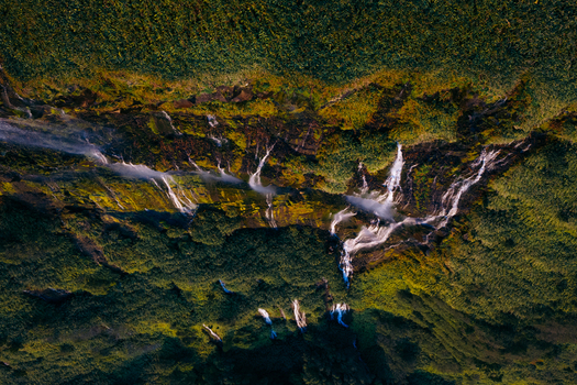 Aerial view of Poco da Ribeira do Ferreiro with multiple waterfalls cascading down steep mossy cliffs and lush green vegetation Fajazinha Azores Portugal. Aerial view of Poco da Ribeira do Ferreiro with multiple waterfalls cascading down steep mossy cliffs and lush green vegetation Fajazinha Azores Portugal.