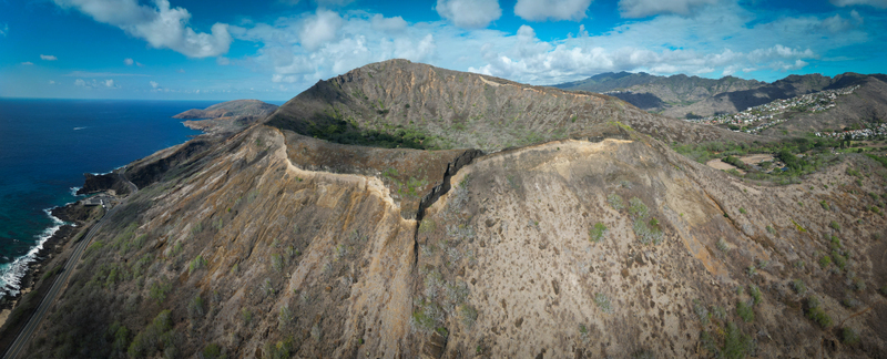 Aerial view of the rugged Koko Head volcano s crater rim juxtaposed against the deep blue ocean and scattered clouds Honolulu Hawaii United States. Aerial view of the rugged Koko Head volcano s crater rim juxtaposed against the deep blue ocean and scattered clouds Honolulu Hawaii United States.
