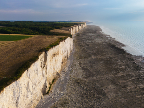 Aerial view of the white chalk cliffs at the Beach of the Bois de Cise overlooking the sea and green fields in Ault Hauts de France France.