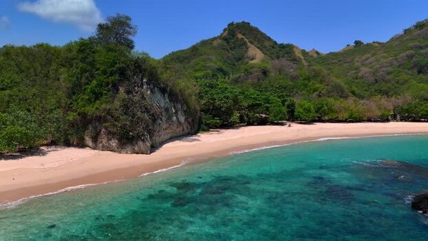 Aerial view of Koka Beach with turquoise water and lush green hills Indonesia Aerial view of Koka Beach with turquoise water and lush green hills Indonesia
