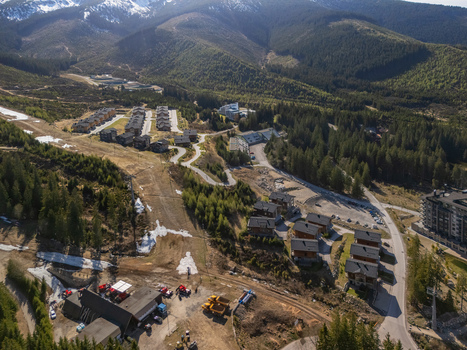 Aerial view of the mountain resort in Demanovska Dolina featuring wooden chalets dense pine forests and snow capped peaks in the background in Demanovska Dolina Zilina Region Slovakia.