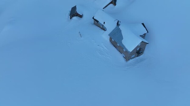 Aerial view of snow covered alpine huts in Italy.