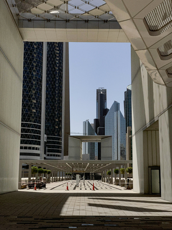 View of modern skyscrapers and geometric architectural structures framing a clear blue sky in the financial district of Dubai Dubai United Arab Emirates. View of modern skyscrapers and geometric architectural structures framing a clear blue sky in the financial district of Dubai Dubai United Arab Emirates.