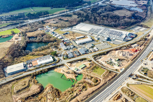 Aerial view of industrial warehouses a quarry with turquoise ponds and the Main Danube Canal surrounded by forests in Forchheim Bavaria Germany. Aerial view of industrial warehouses a quarry with turquoise ponds and the Main Danube Canal surrounded by forests in Forchheim Bavaria Germany.
