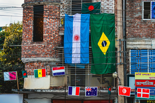Bogura Rajshahi Division Bangladesh 30 November 2022 View of international flags displayed on a brick building facade in the city.