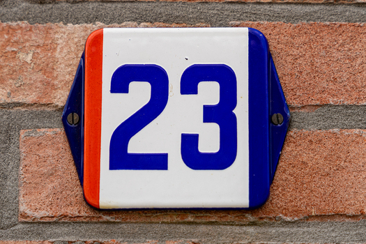 View of a house number sign with the number 23 mounted on a brick wall in Baarle Nassau North Brabant Netherlands.