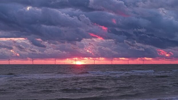 Aerial view of offshore wind farm at sunset Denmark.