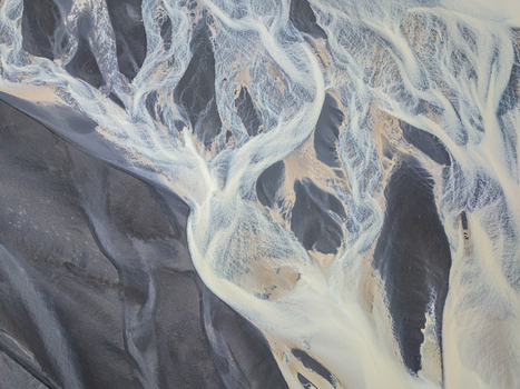 Aerial view of a braided glacial river delta with sediment rich water flowing over dark volcanic sand in Iceland. Aerial view of a braided glacial river delta with sediment rich water flowing over dark volcanic sand in Iceland.