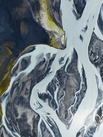 Aerial view of glacial rivers carving through the stark dark landscape creating a mesmerizing contrast of icy blues and earthy tones Highlands Iceland.