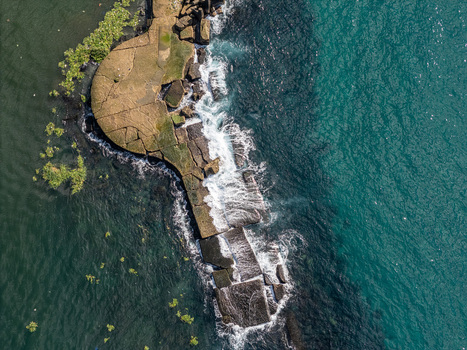 Aerial view of the Rio Ozama mouth where the river meets the Caribbean Sea showing stone fortifications and crashing waves in Santo Domingo Santo Domingo Dominican Republic.