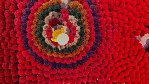 Aerial view of a worker among colorful incense sticks.