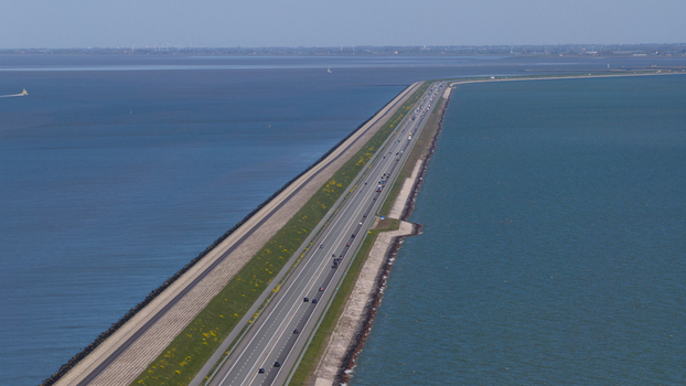Aerial view of the Afsluitdijk causeway at Breezanddijk with traffic on the highway flanked by the Wadden Sea and IJsselmeer Breezanddijk Friesland Netherlands.