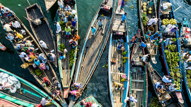Rangamati Bangladesh 19 October 2022 Aerial view of traditional wooden boats filled with people and fresh produce including bananas on the water.