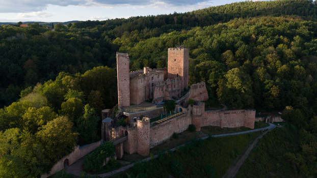 Aerial view of Henneburg castle ruins surrounded by dense forest and rolling hills in Stadtprozelten Bayern Germany.