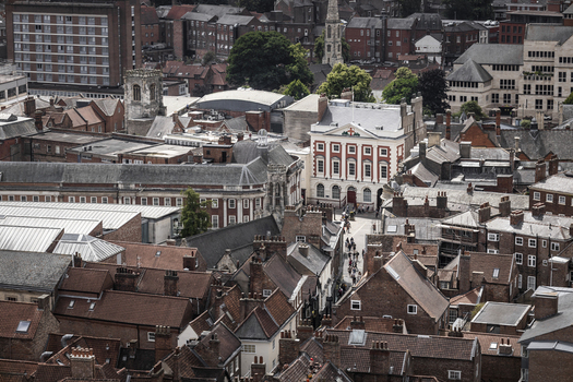 Aerial view of the historic city center of York featuring the Mansion House dense terracotta rooftops narrow streets and traditional brick architecture in York England United Kingdom.