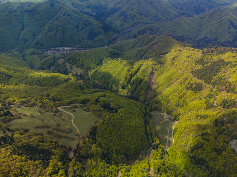 Aerial view of the lush green valley under Spania Dolina with winding forest paths and dense woodland under bright sunlight Spania Dolina Banska Bystrica Region Slovakia.