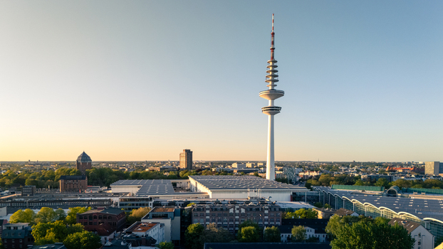 Hamburg Germany 01 May 2026 Aerial view of the Heinrich Hertz Turm telecommunications tower rising above the Hamburg Messe exhibition halls and the city skyline during sunset.