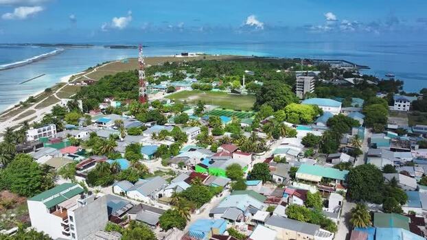 Aerial view of Thulusdhoo island town and turquoise sea Maldives.