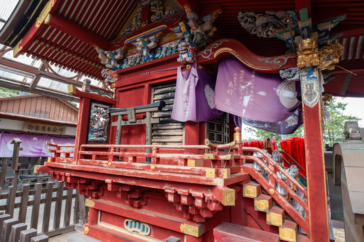View of an ornate red lacquered structure adorned with intricate carvings and purple drapes stands as a testament to cultural heritage Narita Chiba Japan. View of an ornate red lacquered structure adorned with intricate carvings and purple drapes stands as a testament to cultural heritage Narita Chiba Japan.