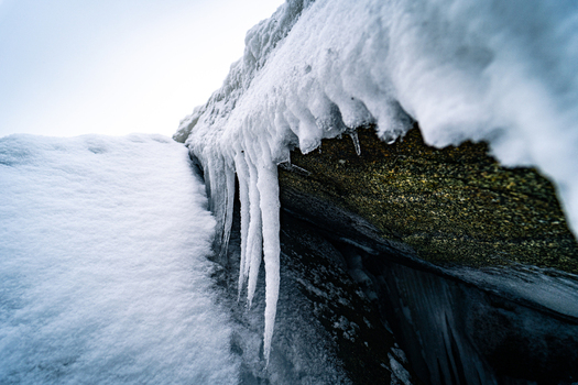 View of icicles hanging from a rocky coastal formation covered in snow and ice in Sassnitz Mecklenburg Vorpommern Germany.