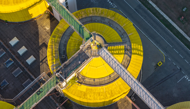 Aerial view of a yellow anaerobic digester with elevated industrial walkways and processing infrastructure at a wastewater treatment plant Italy. Aerial view of a yellow anaerobic digester with elevated industrial walkways and processing infrastructure at a wastewater treatment plant Italy.