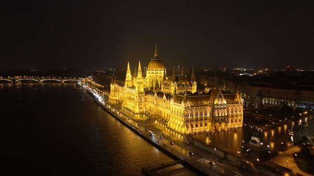Aerial view of the illuminated Hungarian Parliament Building along the Danube River at night in Budapest Hungary. Aerial view of the illuminated Hungarian Parliament Building along the Danube River at night in Budapest Hungary.