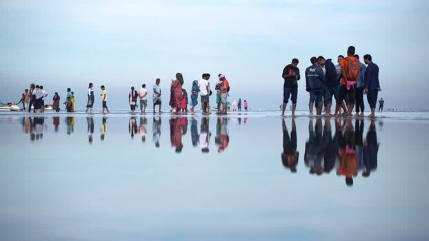 View of people reflected on the wet sand of Cox s Bazar Bangladesh. View of people reflected on the wet sand of Cox s Bazar Bangladesh.