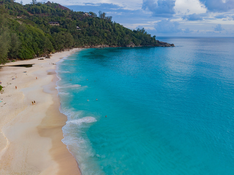 Aerial view of turquoise waters meet the sandy shore embracing the lush greenery of the coastline Quatre Bornes Mahe Island Seychelles. Aerial view of turquoise waters meet the sandy shore embracing the lush greenery of the coastline Quatre Bornes Mahe Island Seychelles.