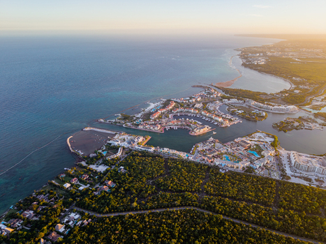 Aerial view of Cap Cana Marina with luxury resort buildings turquoise waters and lush tropical vegetation during golden hour in Punta Cana La Altagracia Province Dominican Republic. Aerial view of Cap Cana Marina with luxury resort buildings turquoise waters and lush tropical vegetation during golden hour in Punta Cana La Altagracia Province Dominican Republic.